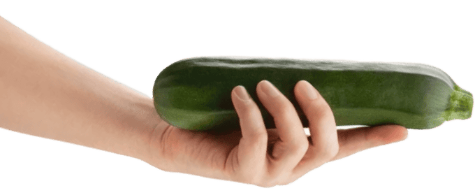 Hand holding a fresh zucchini