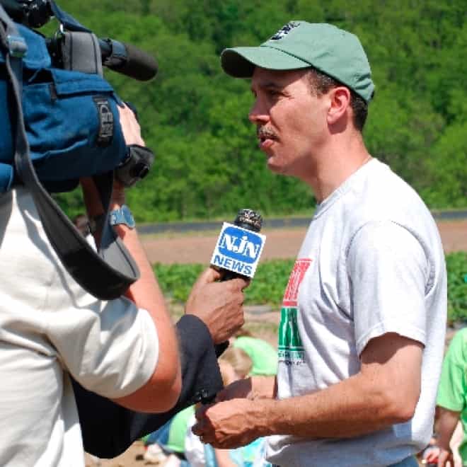 Volunteer being interviewed by news reporter on field day